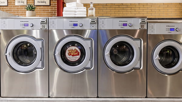 Modern high-capacity washers and dryers inside a clean New Jersey self-service laundromat